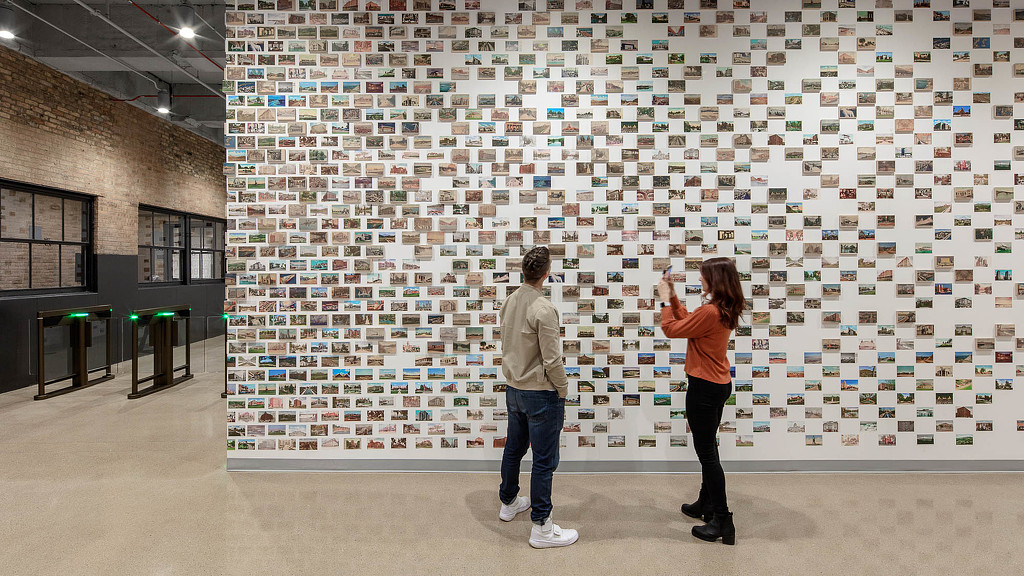 A man and woman looking at a large piece of art.